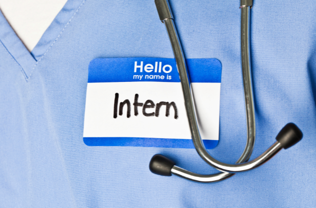 穿著藍色護理服的醫學生胸前掛著「Intern」名牌，象徵澳洲醫護實習經驗。