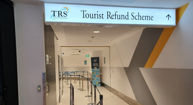機場內 TAX REFUND 指示牌，指引退稅櫃台位置，用於說明澳洲 TRS 辦理地點