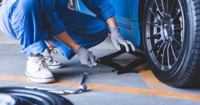 汽車機械師在一輛車旁邊執行維修工作