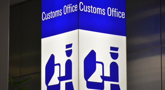 機場中顯示「Customs Office」字樣的海關標誌牌，代表入境旅客需經過的海關檢查點。