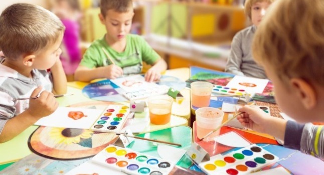 有一個身穿卡其色圍裙的男生在做櫥櫃工作 有黑色紅色耳機