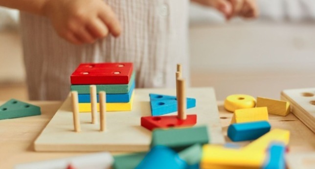 身穿卡其色圍裙的木工在做櫥櫃的工作 黑色紅色耳機