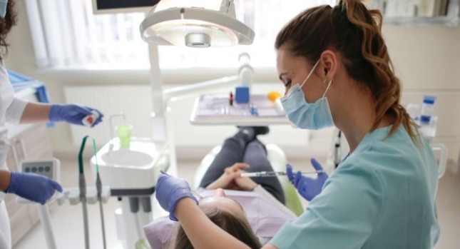 牙醫師以及牙醫助理在看診中