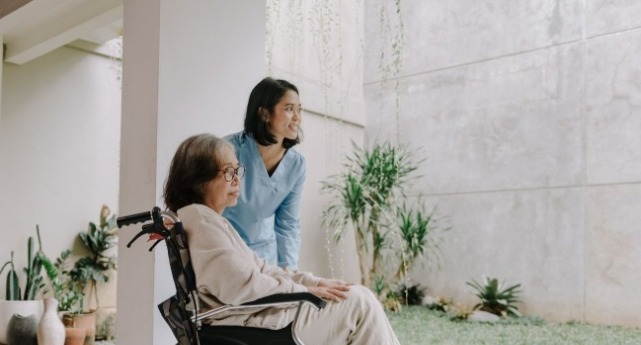 一個照護員帶一個老人看風景