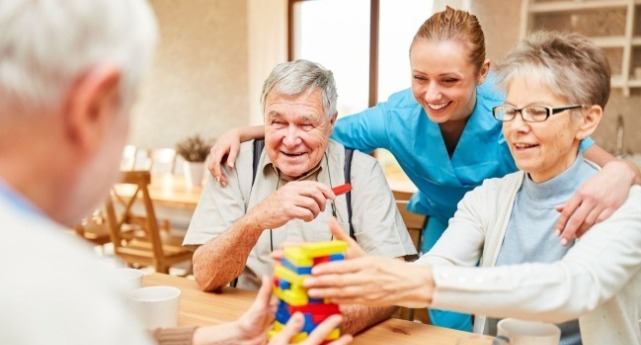 一個照護員帶一群老人做益智活動